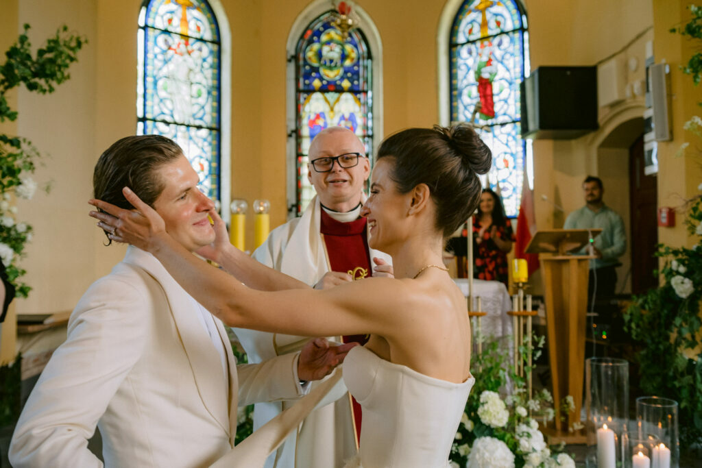 Reporterska fotografia ślubna - WhiteSmoke Studio 28 Czuły gest Natalii wobec Bartosza podczas ceremonii