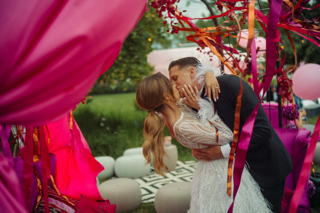 Reporterska fotografia ślubna - WhiteSmoke Studio 10 Pocałunek Laury i Piotra wśród kolorowych wstążek